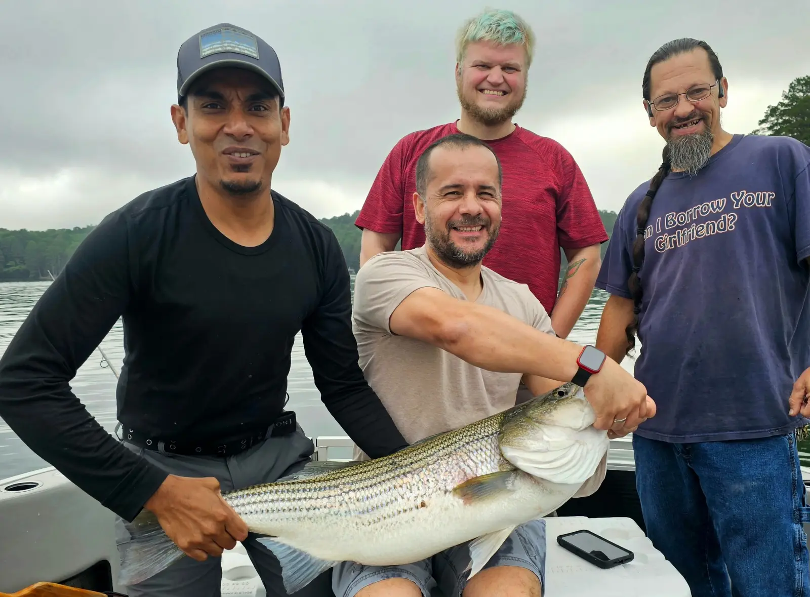 Pro Guide Joseph with a striped bass catch on a cloudy morning