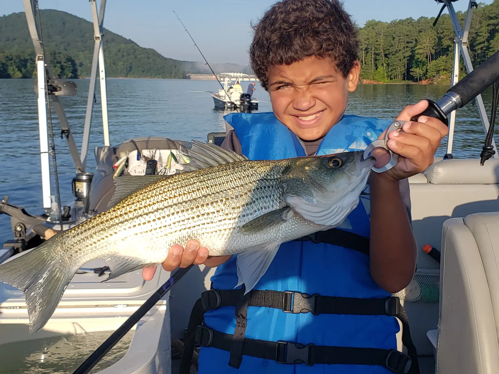 A young girl and her father holding a striped bass on Lake Allatoona